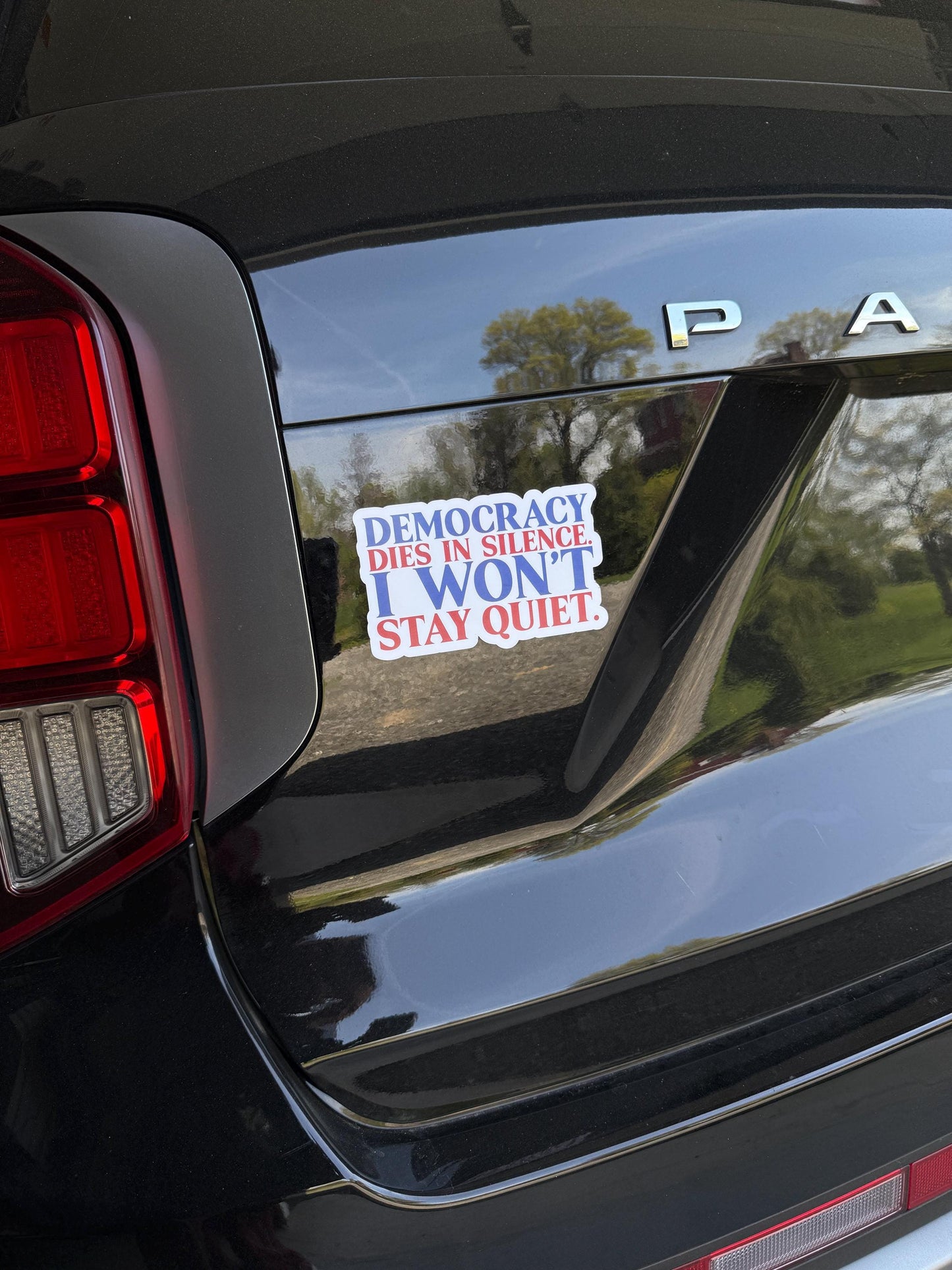 Democracy dies in silence. I won't stay quiet magnet displayed on a car, promoting free speech and resistance.