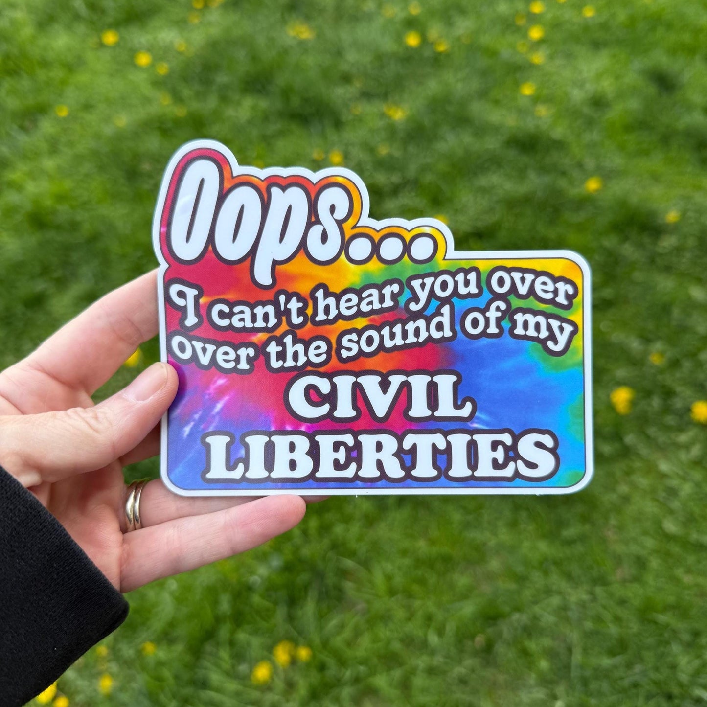 A colorful tie-dye magnet or vinyl decal with bold black text that says "Oops I Can't Hear You Over the Sound of My Civil Liberties," designed for cars, laptops, and more.