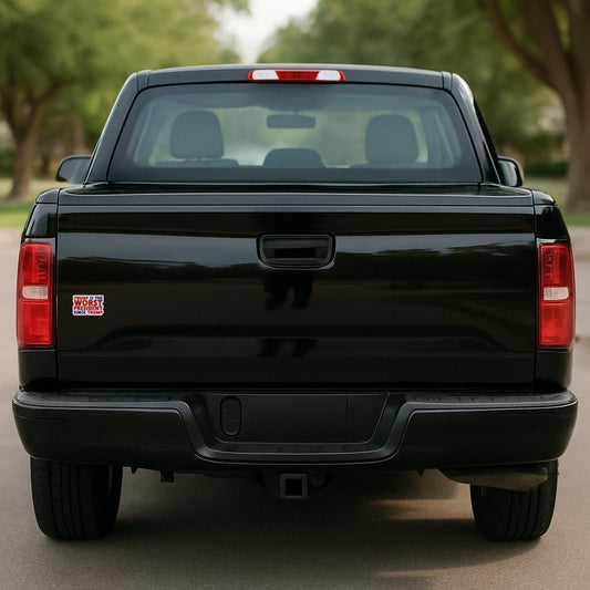 Sticker with text 'TRUMP IS THE WORST PRESIDENT SINCE TRUMP' in red and blue on black pick up truck