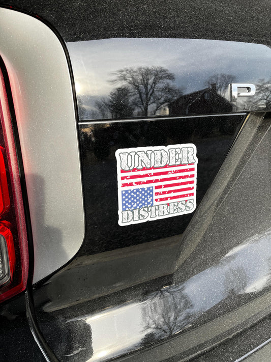 Under Distress magnet featuring an upside-down American flag on the back of a car, symbolizing a nation in crisis.