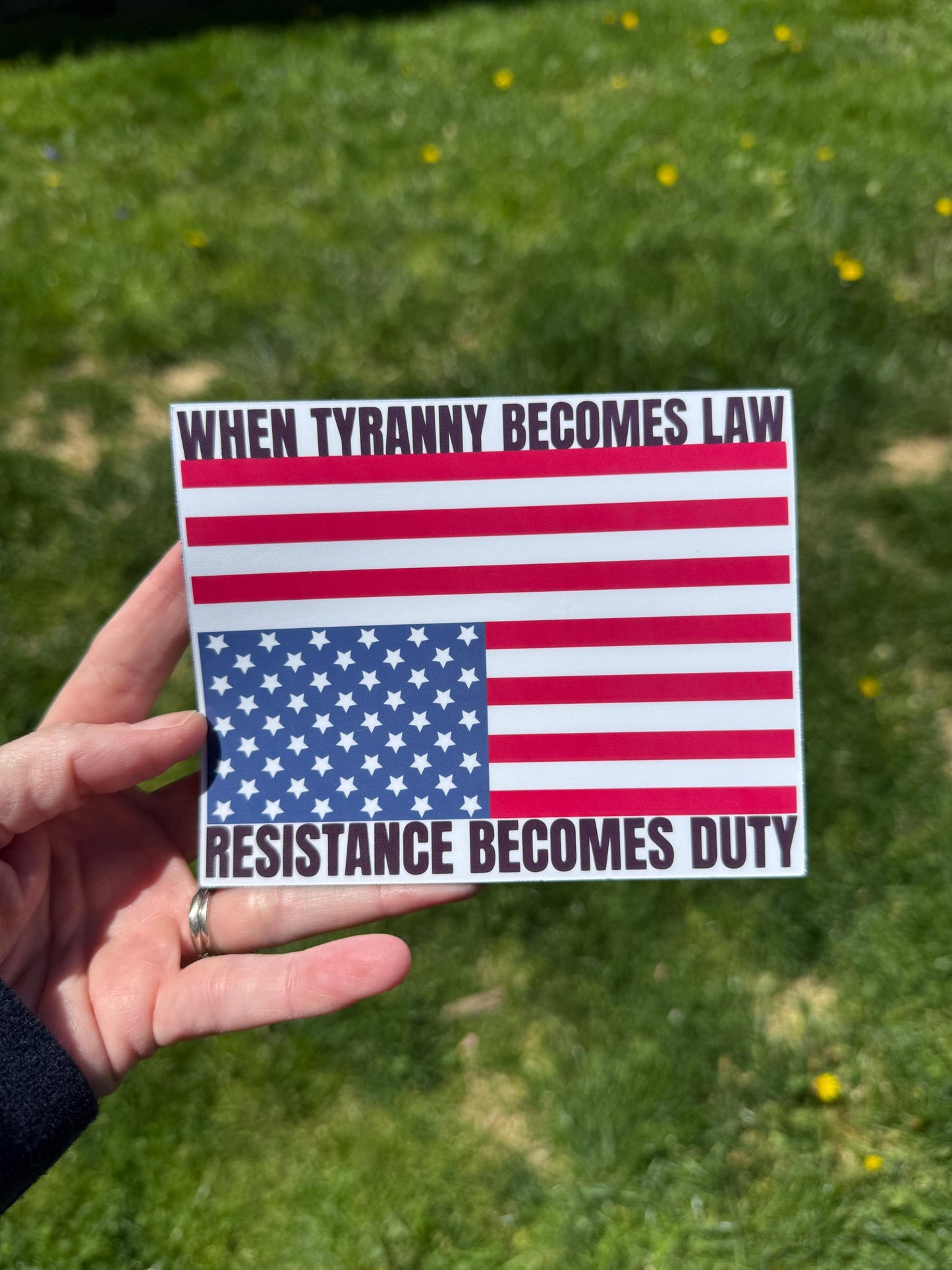 A vinyl decal or magnet displaying the phrase "When tyranny becomes law, resistance becomes duty" in bold lettering, accompanied by an upside-down American flag—a symbol of distress. The design conveys a strong political message about civil resistance.