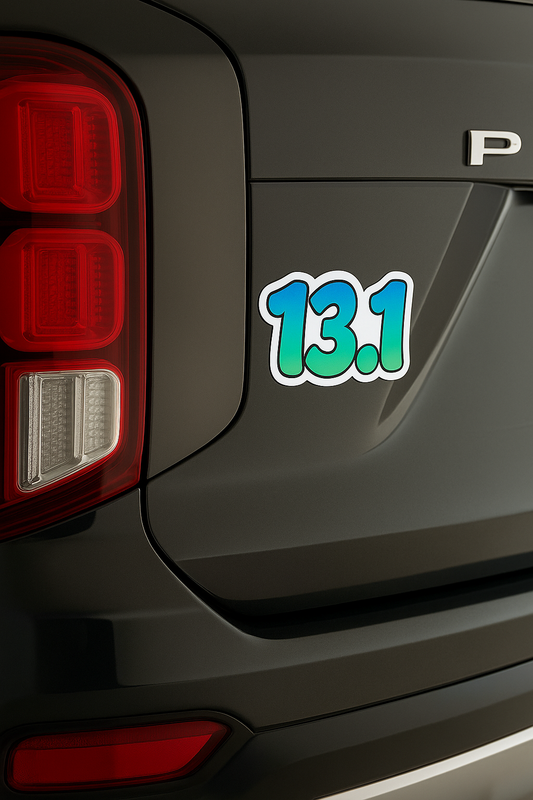 13.1 green and blue gradient half marathon magnet placed on the back of a black SUV near the taillight.