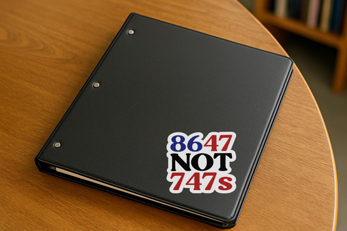 Bold political design reading "86 47 NOT 747s" in red, black, and blue, criticizing Trump’s Qatar plane gift.