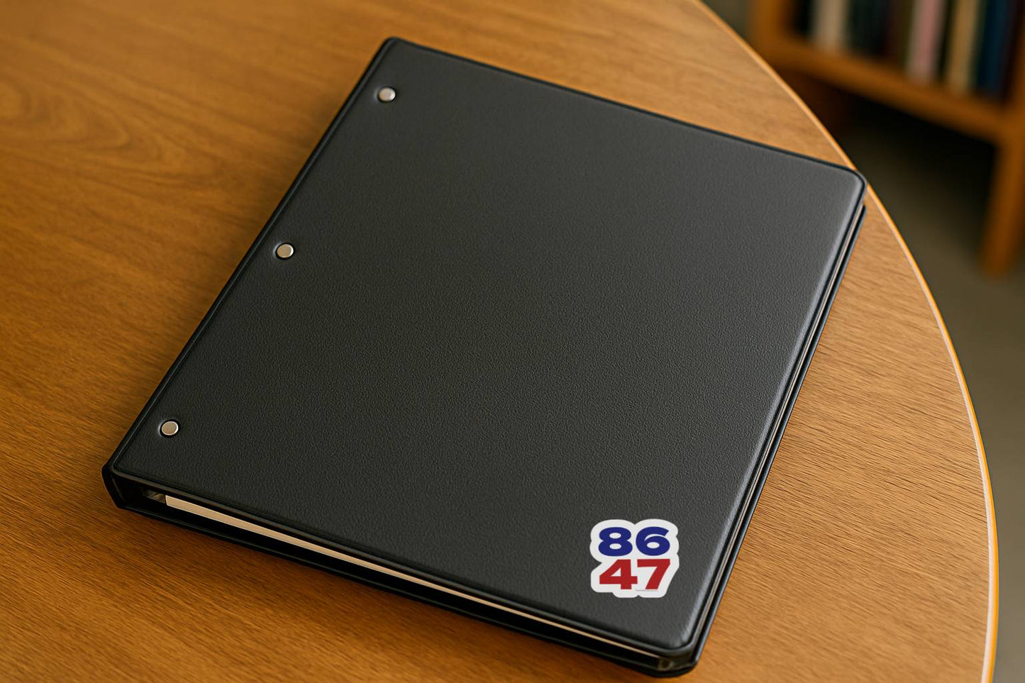 8647 stacked number sticker placed on a black binder resting on a wooden table.