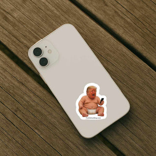 Phone with a sticker of a baby Trump on a wooden surface