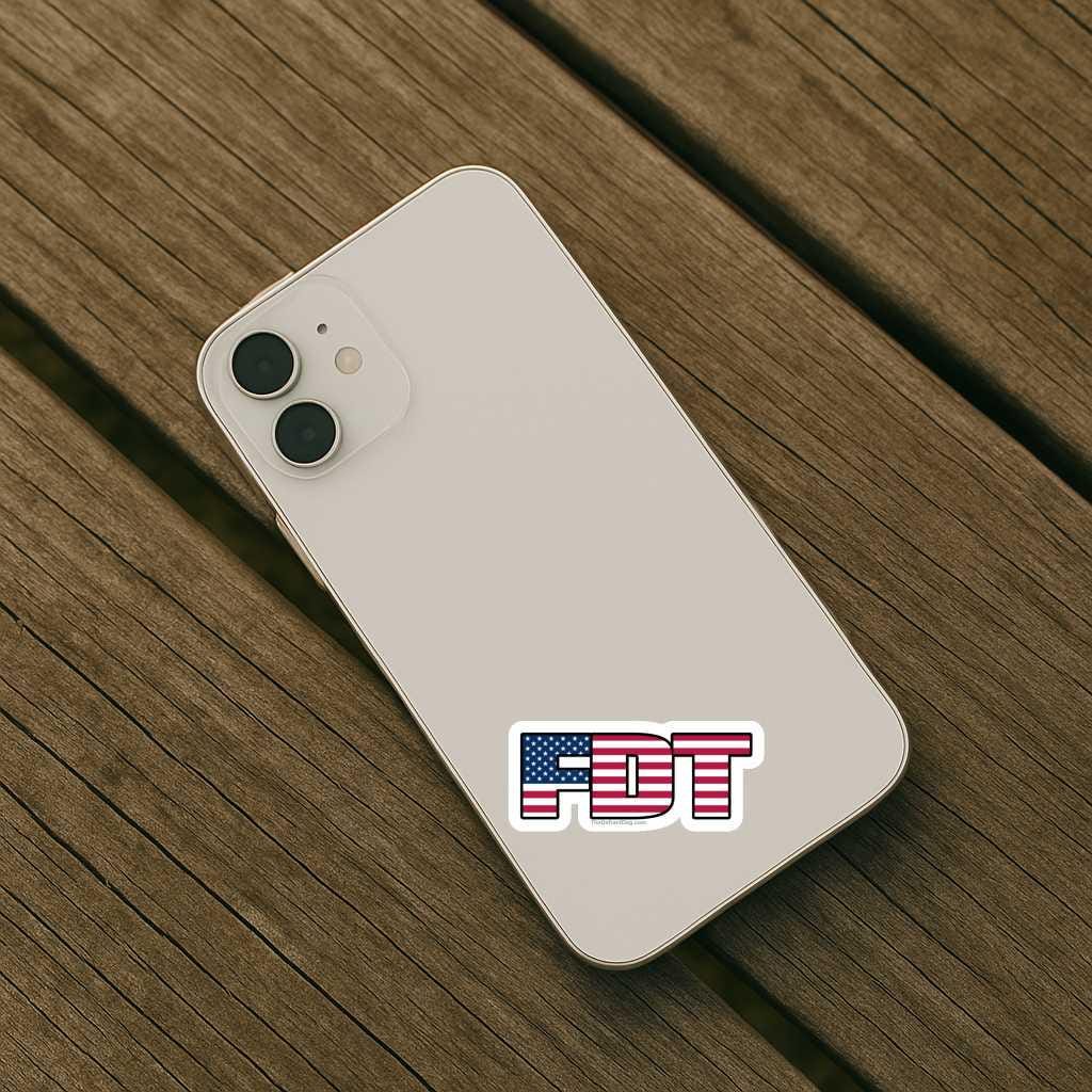 White smartphone with 'FDT' logo on a wooden surface