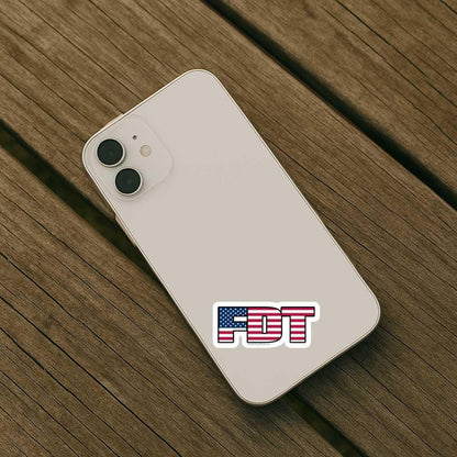 White smartphone with 'FDT' logo on a wooden surface