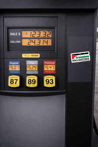 Close-up of a dark gray fuel pump display showing sale price, gallons, and three fuel grade buttons labeled Regular, Plus, and Premium, with a Palestine Energy logo on the right.