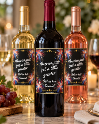 Anti-Trump wine bottle labels on red wine, white wine and rosé bottles, featuring colorful patriotic fireworks, gold stars and the political statement America Just Got a Little Greater, Rot in Hell Donald. Funny political wine stickers displayed at an elegant celebration with the red wine bottle in focus.
