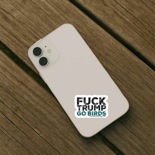 Anti Trump Go Birds sticker placed on the back of a white smartphone, showing the compact size and bold design of a political vinyl decal for phones and personal devices.