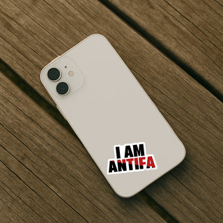 Phone with 'I AM ANTIFA' sticker on a wooden surface