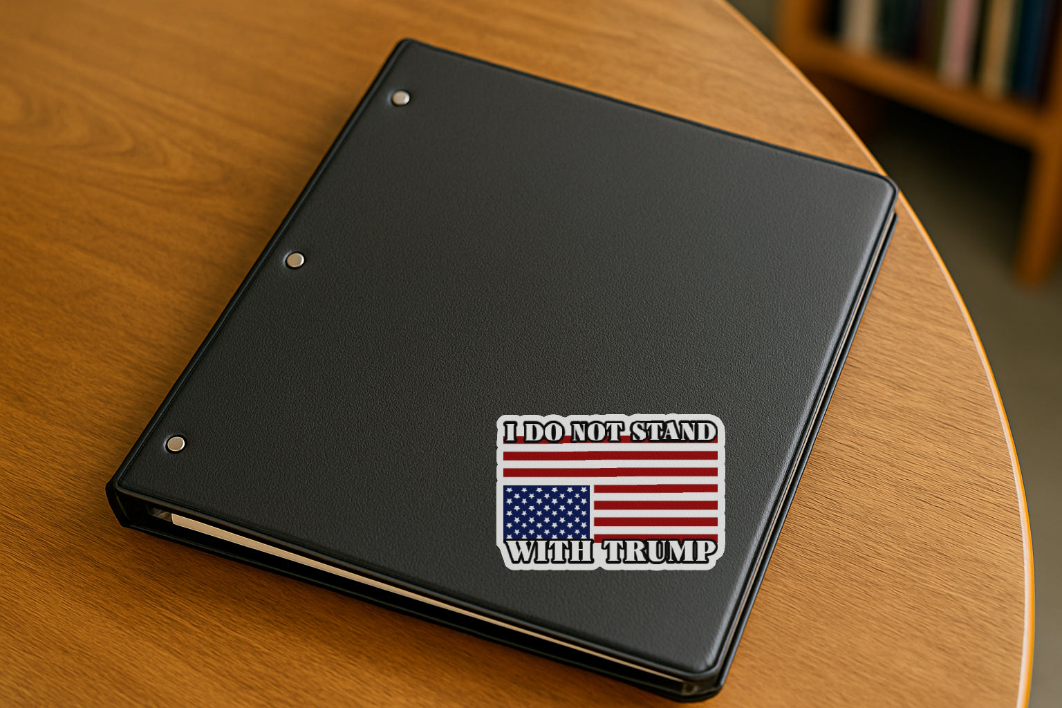 I Do Not Stand with Trump' magnet or vinyl decal displayed on a black binder in a library. A bold, high-quality political sticker perfect for cars, laptops, fridges, or toolboxes. Great for activists, protestors, or anyone fed up with fascism.