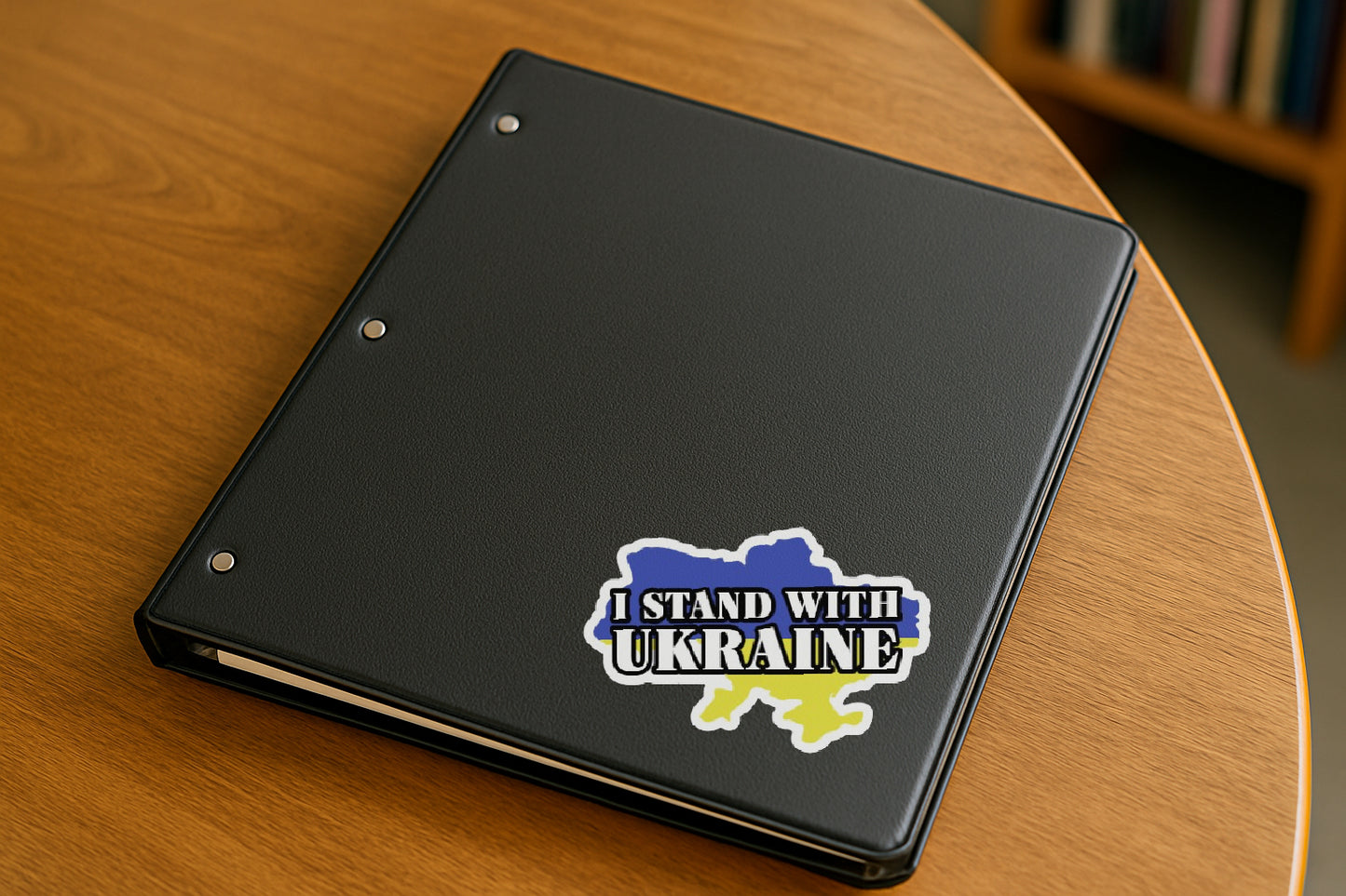 I Stand with Ukraine  Slava Ukraini' magnet or vinyl decal displayed on a black binder in a library. A bold, high-quality political sticker perfect for cars, laptops, fridges, or toolboxes. Great for activists, protestors, or anyone fed up with fascism.