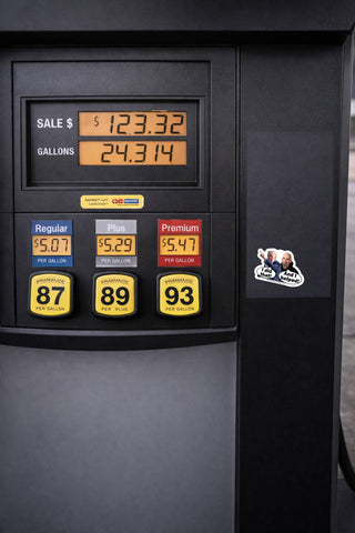 Anti Trump political sticker featuring Donald Trump pointing and John Fetterman saying And I helped placed on a gas pump near fuel price display showing gas prices for satire protest sticker use