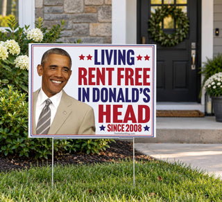 18x24 Barack Obama anti-Trump political yard sign displayed on a metal lawn stake outside a suburban home with landscaping, featuring Living Rent Free Since 2008.