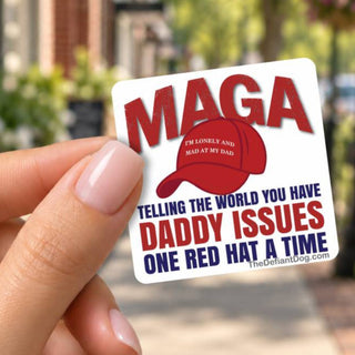 Woman holding a square anti-Trump MAGA Daddy Issues sticker between manicured fingers on a sunny downtown sidewalk. Funny liberal political sticker shows a red MAGA hat and bold red and blue lettering, perfect for laptops, water bottles, and personal accessories.