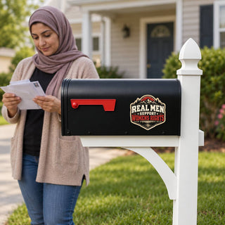 Real Men Support Women’s Rights sticker on black suburban mailbox with woman checking mail in background.