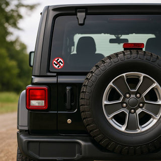 Black Jeep with a swastika sticker on the rear window, parked outdoors.