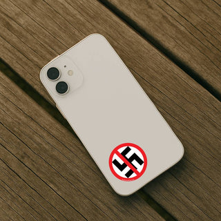 Phone case with a red circle and line over a black swastika symbol on a wooden surface