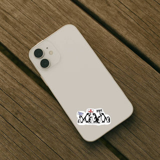 A top-down view of an off-white iPhone resting on a weathered wooden surface. The small penguin sticker is applied to the lower back of the phone case.