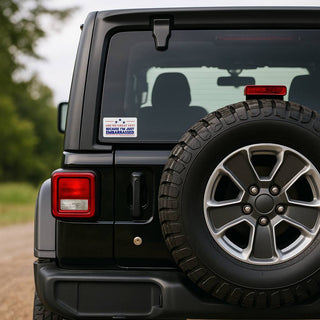 The rear exterior of a black Jeep Wrangler. The "Are We Great Yet?" decal is applied to the lower-left corner of the rear glass window, positioned next to the spare tire.
