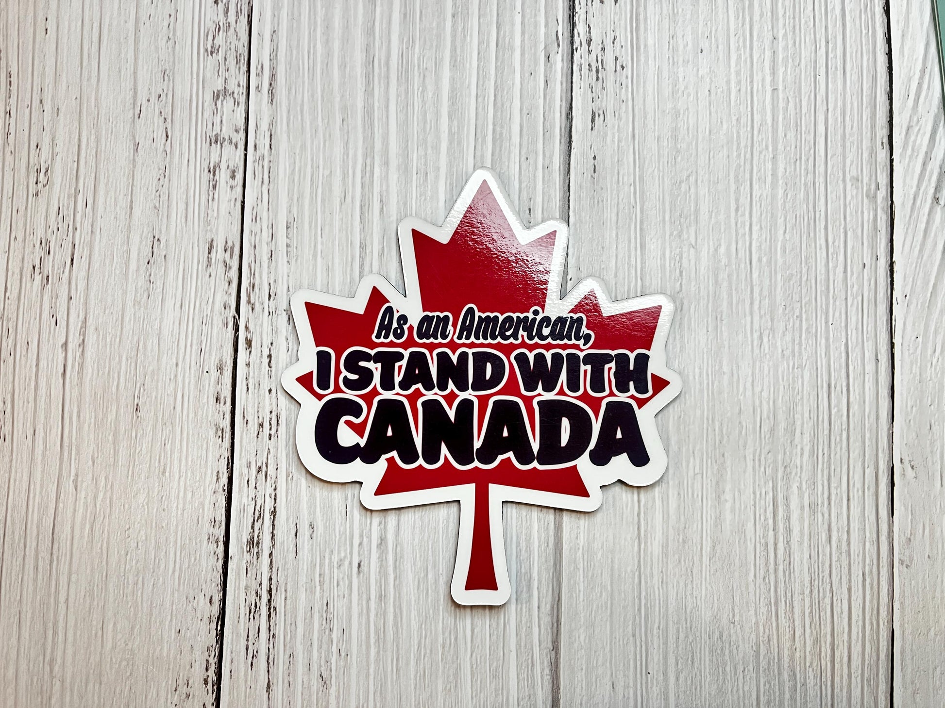 As an American, I Stand With Trump magnet in white text displayed on a table as a liberal political statement