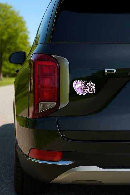 Sticker with purple dinosaur, pink baby dinosaur, and 'Baby on Board' text on a palisade
