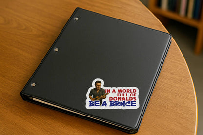 Sticker with a graphic of a Bruce Springsteen playing guitar and text 'In a world full of Donalds be a Bruce' on a notebook