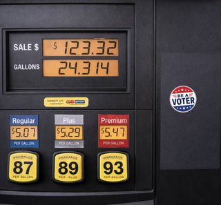 Red, white, and blue “Be a Voter” sticker on the side panel of a black gas pump beside the fuel display.