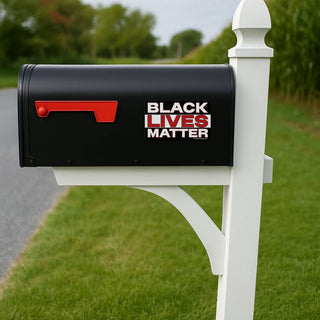 Black mailbox with 'Black Lives Matter' text on a white post in a grassy area.