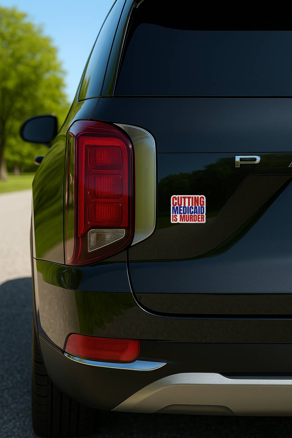 Black car with a political sticker on the back, outdoors.