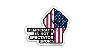 Sticker with American flag and fist graphic with text 'Democracy is not a spectator sport' on a white background.