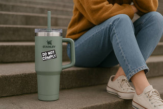 Person sitting on steps with a green Stanley tumbler and 'No One Is Too Small For Me' sticker.