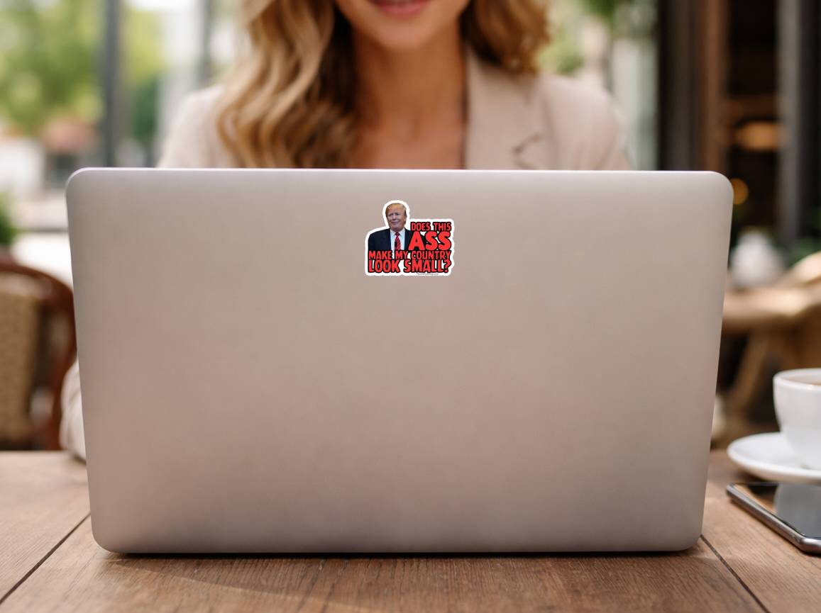 Silver laptop featuring Does This Ass Make My Country Look Small anti Trump protest sticker centered on the back. Bold red and black text design ideal for laptops and tech accessories.
