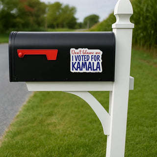 Black mailbox with a sticker reading 'Don't blame me, I voted for Kamala' on a grassy area.