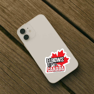 A white smartphone lying on a weathered wooden surface, with a red and black sticker on the back that reads 'ELBOWS UP FOR CANADA' with a maple leaf graphic.