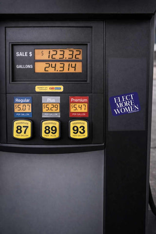Gas pump display with fuel prices and a sticker advocating for women's rights.