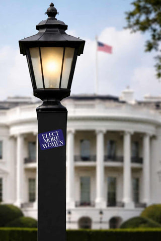 Lamp post with 'Elect More Women' sticker in front of the White House