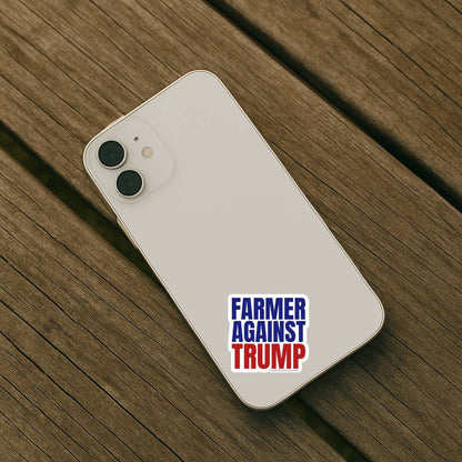 White smartphone with 'Farmer Against Trump' sticker on a wooden surface