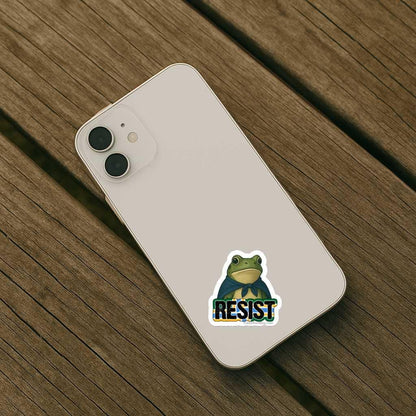 Phone case with a frog graphic and 'RESIST' text on a wooden surface