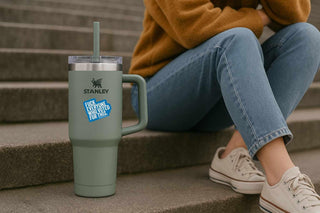 Person sitting on steps with a Stanley tumbler