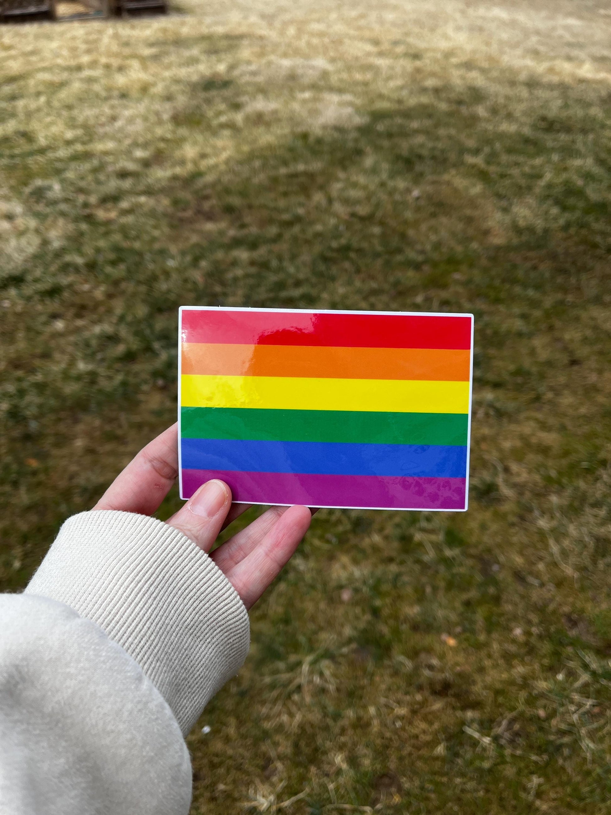 'Gay Pride Flag' magnet or vinyl decal displayed with a slight shadow on a white background. A bold, high-quality political sticker perfect for cars, laptops, fridges, or toolboxes. Great for activists, protestors, or anyone fed up with fascism.