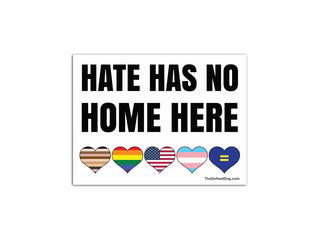 White Hate Has No Home Here yard sign displayed beside a suburban road with five colorful equality and Pride hearts.