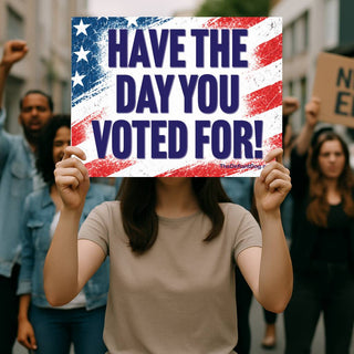 Protester holding Have the Day You Voted For political sign with bold blue lettering and distressed American flag background at an outdoor demonstration.