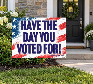 Have the Day You Voted For anti-Trump political lawn sign displayed on metal stakes in front of a suburban home, featuring a distressed patriotic American flag design.