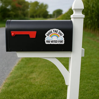Black mailbox with a sticker on a white post in a grassy area