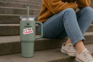 Person sitting on steps with a green Stanley tumbler and 'Recall Trump' sticker.