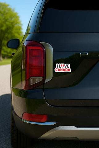 Car with a humorous sticker on the back, outdoors.