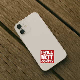 Phone case with 'I WILL NOT COMPLY' text on a wooden surface