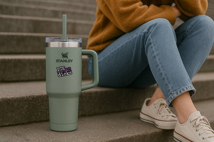 Person sitting on steps with a Stanley tumbler and 'ICE agents have small dicks' sticker.